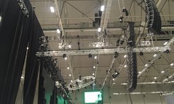 Des palans électriques à chaîne transportent des tours de haut-parleurs sur une scène intérieure