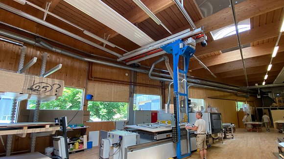 A GIS crane system with storage and retrieval unit ensures that the wooden boards are quickly and effortlessly transferred from the cantilever rack to the work table of the machine