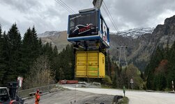 Système de transport de charges GIS A la station aval, la cabine prend en charge un conteneur pour le transport sous charge suspendue. L'opérateur commande le processus par radiocommande.