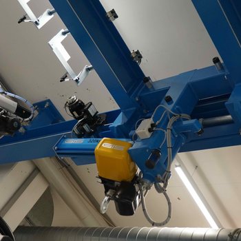 The travelling crane is moved in longitudinal direction. To do this, the slewing crane is locked in place and moved between the column and the handling robot.