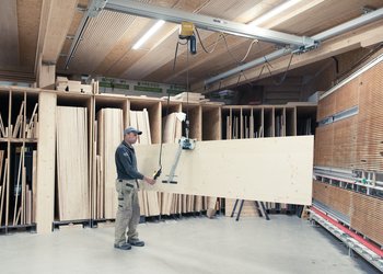 Elektrokettenzug zusammen mit Plattengreifer zum Heben von Holzplatten