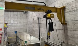 The wall-mounted slewing crane is attached to a concrete wall