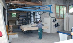 Wall-mounted slewing crane with hose lifter