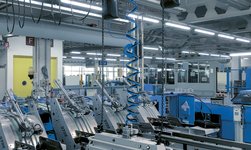 Dans une imprimerie, les rouleaux de papier sont soulevés par un palan à chaîne synchrone.